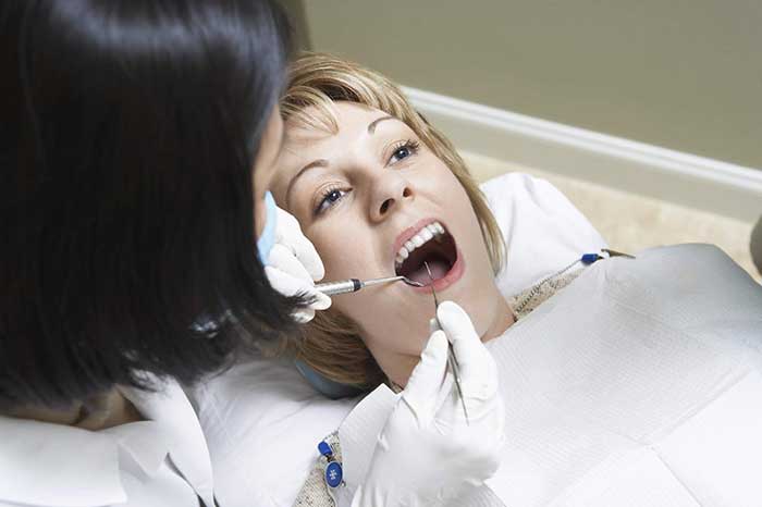 Lady dentist checking a woman's teeth