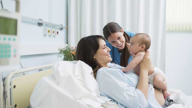 Woman in hospital holding her new born baby