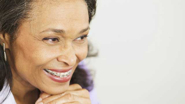 Adult woman wearing braces smiling