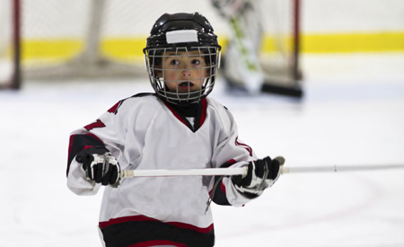 Child playing minor hockey in the arena