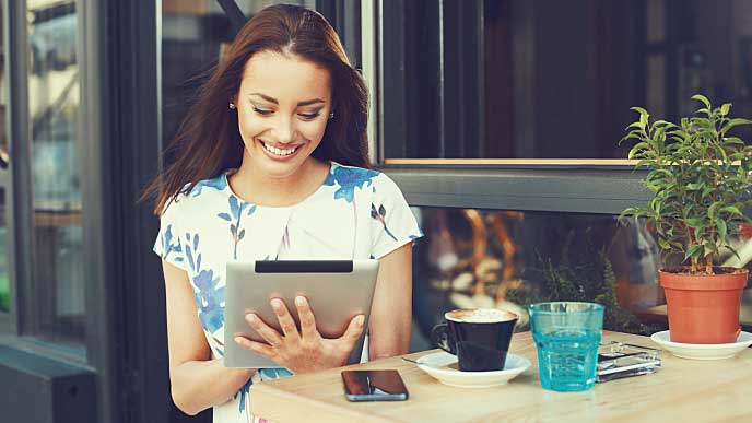 Happy woman checking on tablet